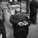 Scène de rue avec passants et homme lisant un journal