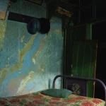 Chambre ancienne avec lit et mur dégradé