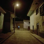 Ruelle de village la nuit sous un lampadaire