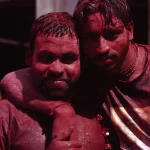 Deux hommes couverts de poudre rouge lors d'un festival