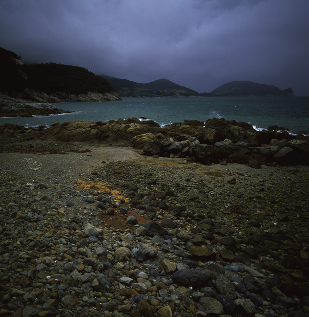 AKG813516.webp Paysage côtier rocheux par temps nuageux – Image 1