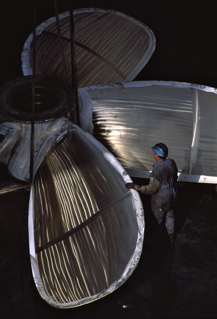 AKG817161.webp Ajustement d'une grande hélice en atelier industriel – Image 1