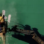 Travailleurs en hauteur réparant une surface métallique