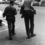 Deux hommes marchant dans la rue avec des voitures en arrière-plan