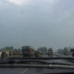 Route encombrée par des camions sous un ciel nuageux