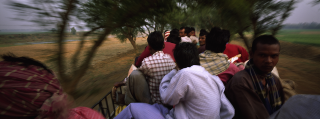 AKG820788.webp Groupe de personnes voyageant sur un véhicule en mouvement – Image 1