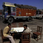 Repas en plein air devant des camions colorés