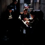 Groupe de personnes jouant à un jeu de cartes dans une maison traditionnelle