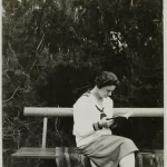 Femme lisant un livre sur un banc en forêt