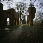 Ruines d'un ancien bâtiment en briques devant un parc naturel