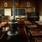 Vieille salle de classe avec poêle à bois et tableaux noirs