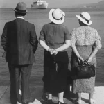 Trois personnes regardant un bateau en mer