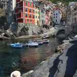 Village coloré près de la mer avec bateaux et touriste