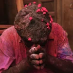 Homme participant à une célébration avec des poudres colorées