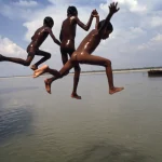 Enfants sautant dans une rivière