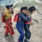 Enfants avec des parapluies sous la pluie