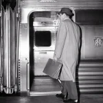 Homme montant dans un train avec une mallette