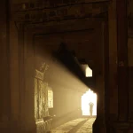 Personne sous les rayons de soleil dans un couloir de pierre historique