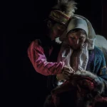 Mère et fille en costume traditionnel brodant