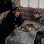 Partie d'échecs entre générations dans un intérieur traditionnel