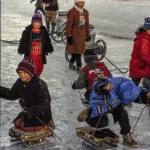 Enfants jouant sur glace avec des luges artisanales