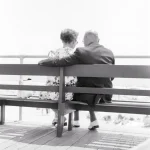 Couple âgé assis sur un banc, dos à la caméra