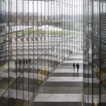 Vue Intérieure d'un Bâtiment Moderne avec Réflexions et Deux Personnes Marchant