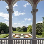 Jardin vu à travers des colonnes classiques sous ciel bleu