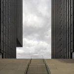 Escalier entre deux immeubles modernes sous un ciel nuageux
