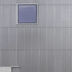 Homme promenant un chien devant un bâtiment moderne