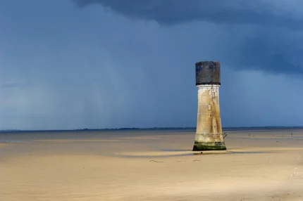 Phare isolé sur une plage déserte au crépuscule