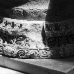 Base sculptée d'une colonne en pierre éclairée par la lumière naturelle