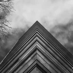 Gratte-ciel vu d'en bas avec ciel orageux.