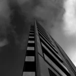 Bâtiment moderne sombre sous des nuages menaçants