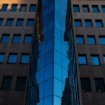 Immeuble en verre moderne avec reflets urbains