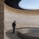 Homme marchant dans une structure circulaire architecturale en extérieur