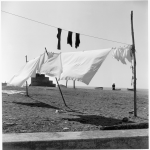 Linge séchant au soleil sur une plage avec personne au loin