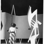 Femme observant une sculpture abstraite