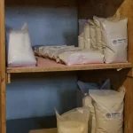 Sacs de poudre de pierre ponce sur des étagères en bois