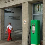 Vieil homme près d'une ancienne pompe à essence BP
