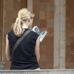 Femme lisant un dépliant en extérieur