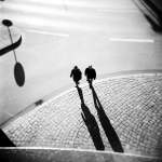 Deux personnes marchant dans une rue pavée.