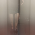 Personne en jupe avec une valise dans un ascenseur