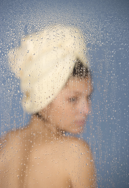 AKG8686977.webp Femme avec serviette derrière une vitre mouillée – Image 1