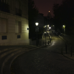 Rue pavée et éclairée la nuit avec le dôme en arrière-plan