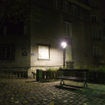 Banc sous un réverbère dans une ruelle pavée la nuit