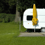 Caravane blanche avec parasol jaune en plein air