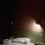 Lit défait dans une chambre faiblement éclairée