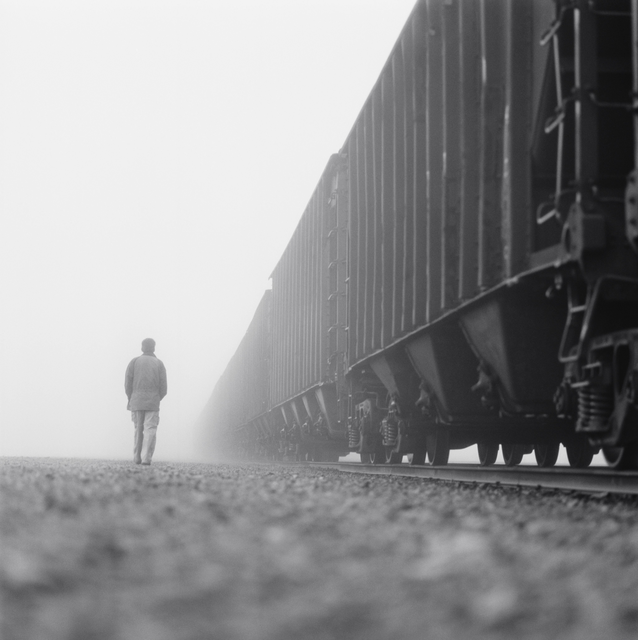 AKG8687026.webp Homme marchant près d'un train dans le brouillard – Image 1