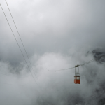 Téléphérique traversant des nuages en montagne